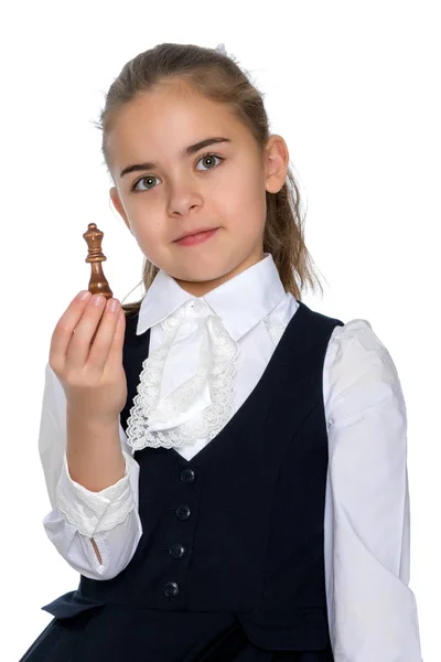 Den lilla flickan håller en schackpjäs i handen. — Stockfoto