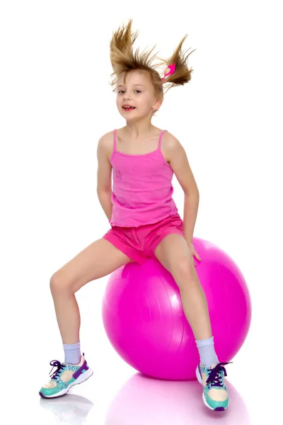 Mała dziewczynka skacze na piłka gimnastyczna Duże. — Zdjęcie stockowe