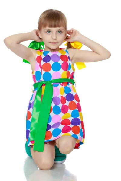 A little girl in a dress with a pattern from multi-colored circl — Stock Photo, Image