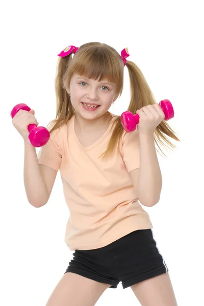 Little girl doing exercises with dumbbells. — Stock Photo, Image