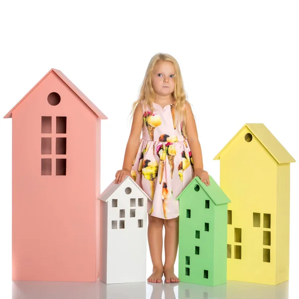 Niña está jugando con casas de madera . — Foto de Stock