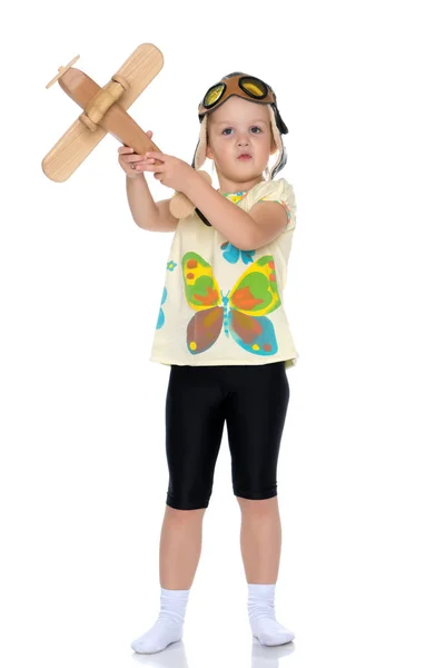 Klein meisje met een houten vliegtuig in haar hand. — Stockfoto