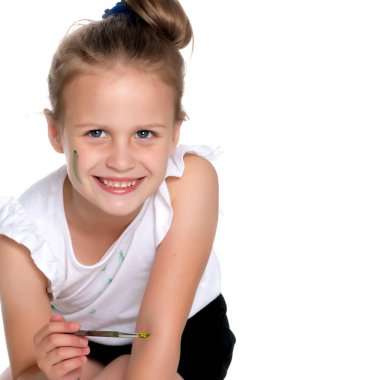 Küçük bir kız boya ve fırça ile boya.