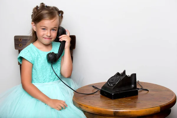 A little girl is ringing on the old phone. — Stock Photo, Image