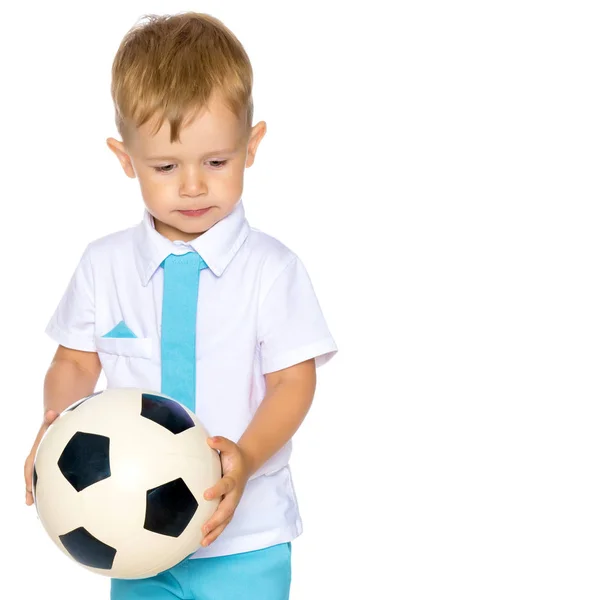 Um menino está brincando com uma bola . — Fotografia de Stock