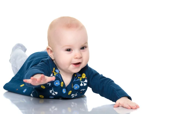 Een leuk, zeer weinig meisje ligt op de vloer op een witte backgr — Stockfoto