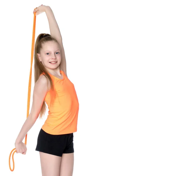 Uma ginasta executa exercícios com uma corda pulando. — Fotografia de Stock