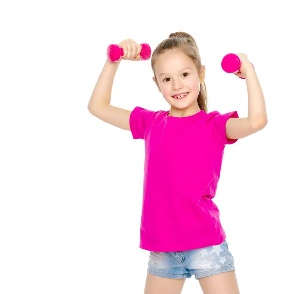 Little girl doing exercises with dumbbells. — Stock Photo, Image