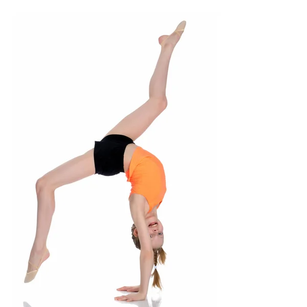 Gimnastyczka wykonuje stojak na rękę z zgiętymi nogami.. — Zdjęcie stockowe