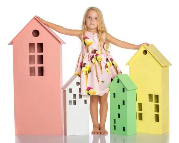 Little girl is playing with wooden houses. — Stock Photo, Image