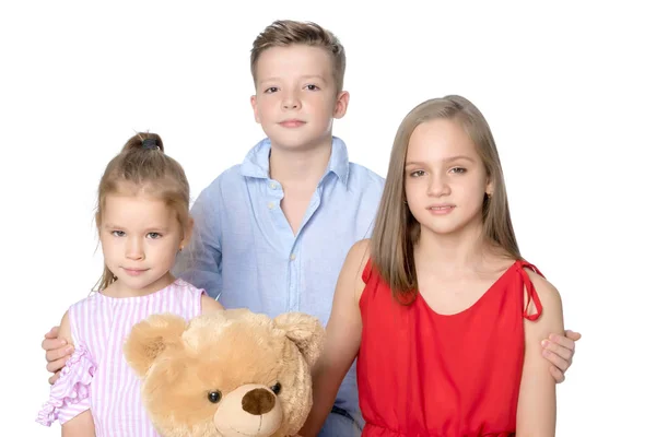 Brother and two sisters with a teddy bear — Stock Photo, Image