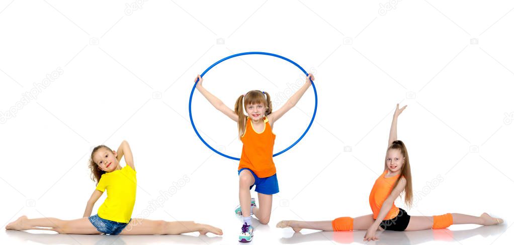 A group of girls gymnasts perform exercises.