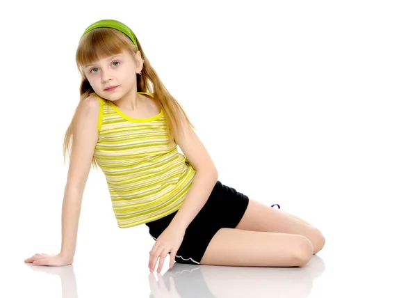 Een klein meisje doet gymnastiek oefeningen. — Stockfoto