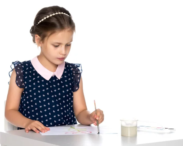 Uma menina pinta com tinta e pincel . — Fotografia de Stock