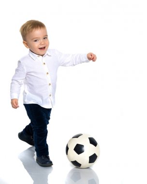 Küçük çocuk bir futbol topuyla oynuyor.