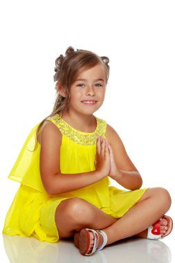 Küçük kız yerde oturuyor..