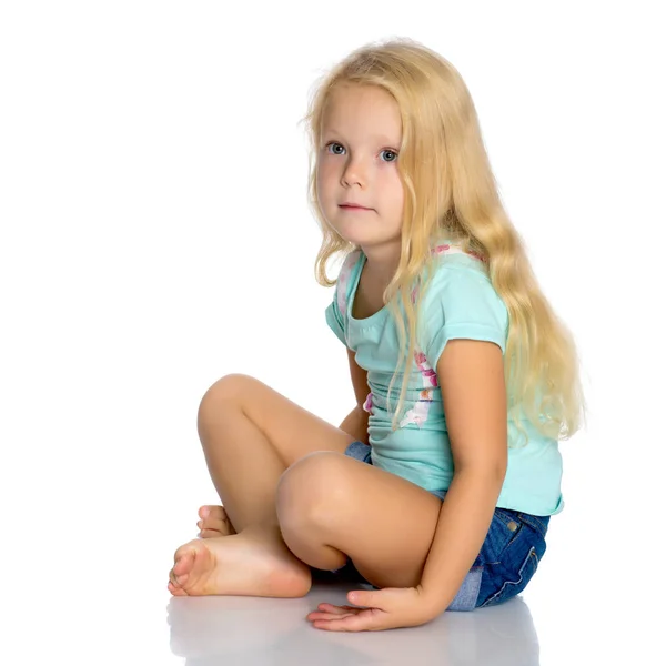 Kleines Mädchen sitzt auf dem Boden. — Stockfoto