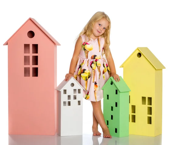 Little girl is playing with wooden houses. — Stock Photo, Image