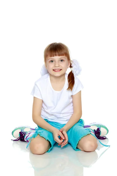 Uma menina em uma camiseta branca e shorts . — Fotografia de Stock