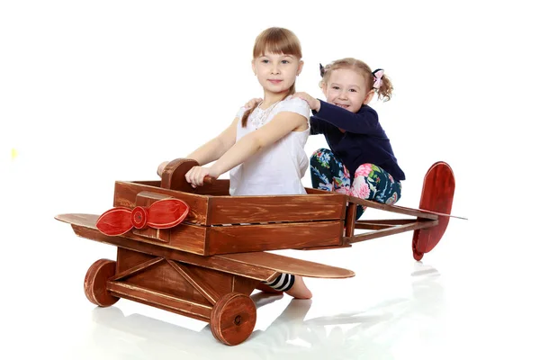 Two sisters playing in a wooden plane — Stock Photo, Image