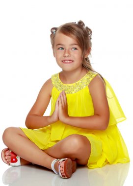 Küçük kız yerde oturuyor..