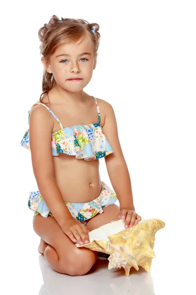 Bambina in costume da bagno con conchiglia — Foto Stock