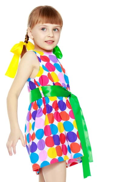 Une petite fille dans une robe avec un motif de cirque multicolore — Photo