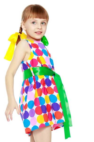 Una niña en un vestido con un patrón de circl multicolor — Foto de Stock