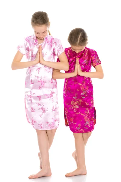 Girls are sisters in Chinese national dresses. Royalty Free Stock Photos