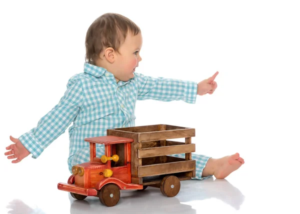 Um menino está brincando com um carro de brinquedo. — Fotografia de Stock