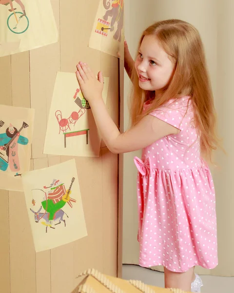 Une petite fille joue dans une maison en carton — Photo