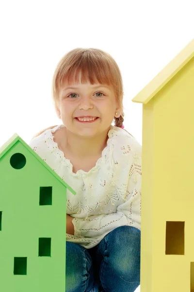 Маленька дівчинка грає з дерев'яними будинками . — стокове фото