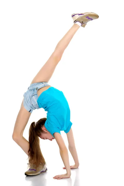 Le gymnaste effectue un pont avec une jambe relevée . — Photo