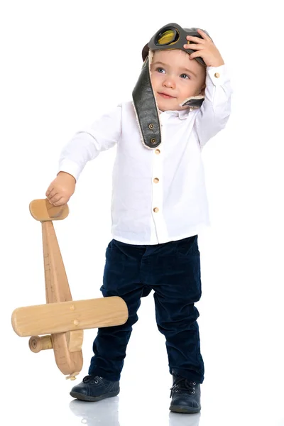 Liten pojke med ett trä plan. — Stockfoto
