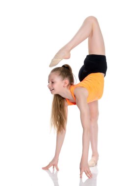 Jimnastikçi yerde akrobatik bir element sergiliyor..