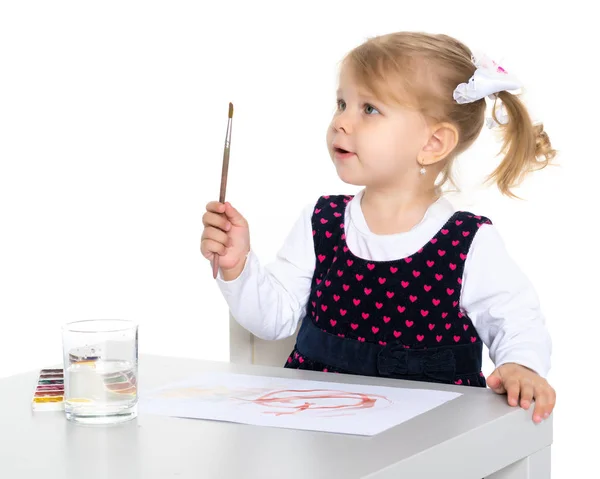 Uma menina está desenhando na mesa . — Fotografia de Stock