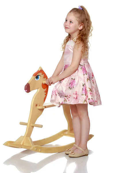 Chica balanceándose en un caballo de madera . —  Fotos de Stock