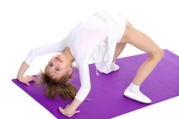 The little gymnast performs a bridge. — Stock Photo, Image