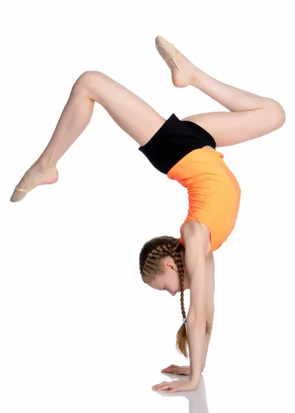 Die Turnerin macht einen Handstand mit angewinkelten Beinen. — Stockfoto