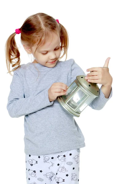 Una niña está sosteniendo una lámpara . —  Fotos de Stock