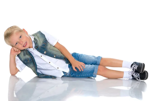 Un niño está tirado en el suelo en el estudio . — Foto de Stock