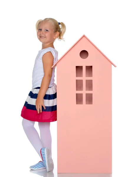 Little girl is playing with wooden houses. — Stock Photo, Image