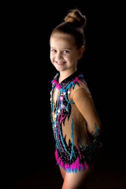 Küçük kız jimnastikçi bir güzel sportif mayo üzerinde siyah bir ba