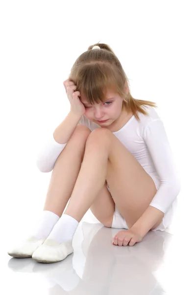 Menina ginasta senta-se no chão e chora — Fotografia de Stock