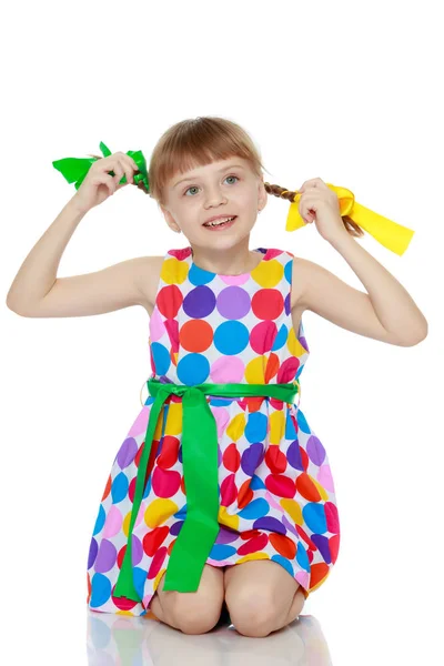 Una niña en un vestido con un patrón de circl multicolor — Foto de Stock