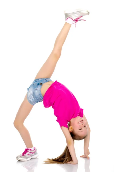 Gimnastyk wykonuje most z podniesionej nogi. — Zdjęcie stockowe