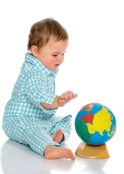 Um menino está brincando com um globo . — Fotografia de Stock