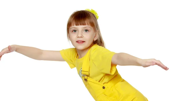 Chica con un flequillo corto en la cabeza y un mono amarillo brillante . —  Fotos de Stock