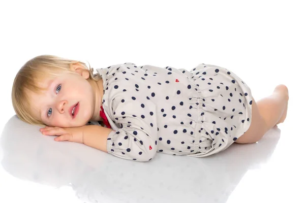Malá holčička leží na podlaze — Stock fotografie