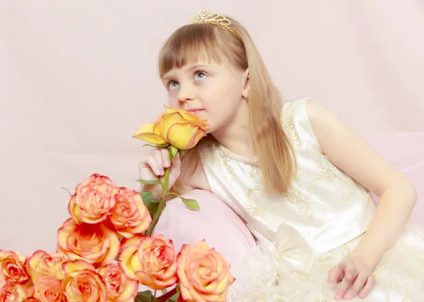 Girl sits next to a bouquet of flowers. — Stock Photo, Image